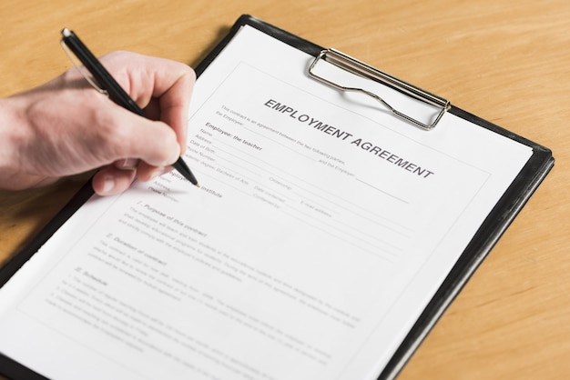 High angle of man signing contract for new job