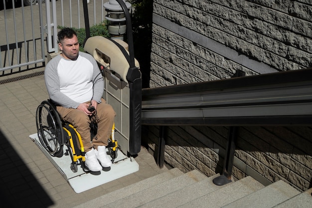 Человек высокого угла в инвалидной коляске на открытом воздухе