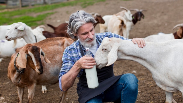 Uomo di alto angolo con una bottiglia di latte di capra