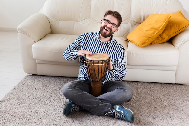 Free photo high angle of man with drum at home