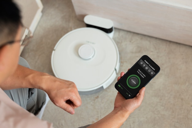 High angle man with robotic vacuum cleaner at home