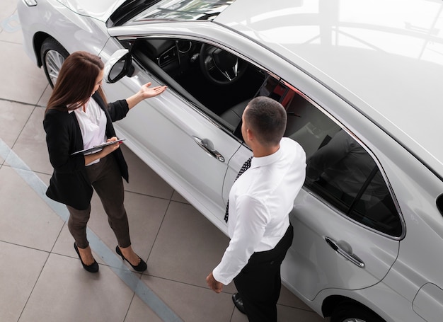 high angle man and woman at dealership