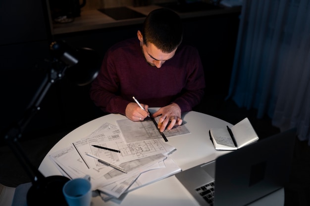 Free photo high angle man working late at night