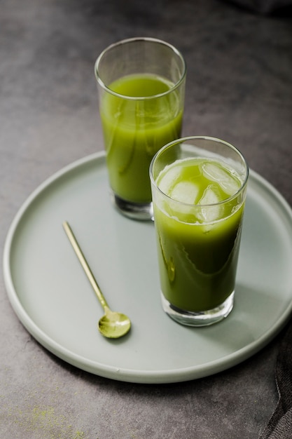 High angle of matcha tea glasses with ice cubes