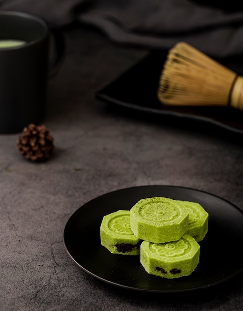 High angle of matcha tea with pine cone and bamboo whisk