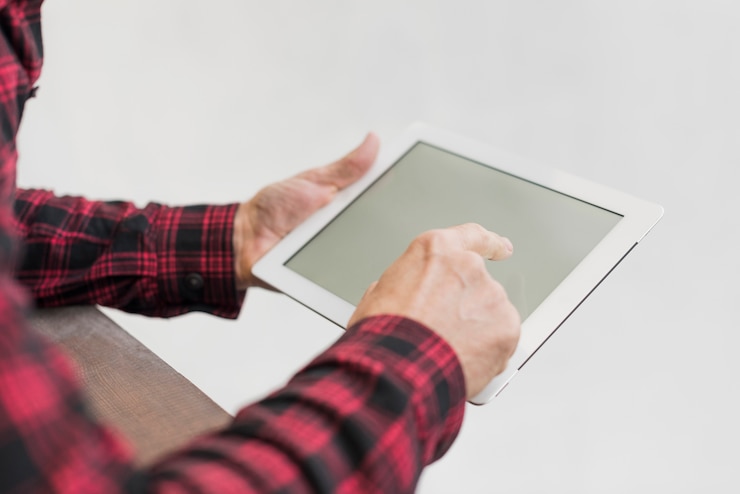 Free Photo high angle mature man looking on his tablet