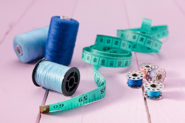 High angle of measuring tape with thread reels and sewing machine shutles