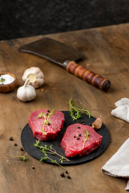 High angle of meat with herbs and cleaver