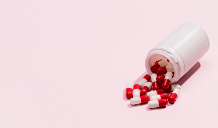 Free Photo high angle medicine bottle with pills