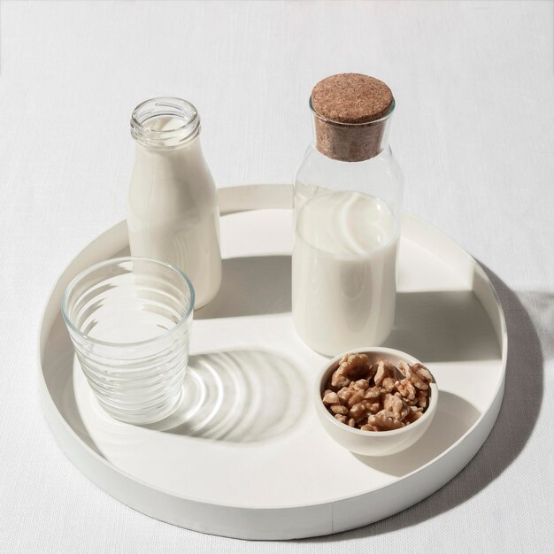 High angle of milk bottle with walnuts on tray