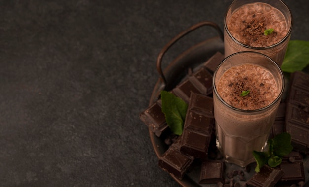 チョコレートとコピースペースのトレイにミルクセーキグラスの高角度