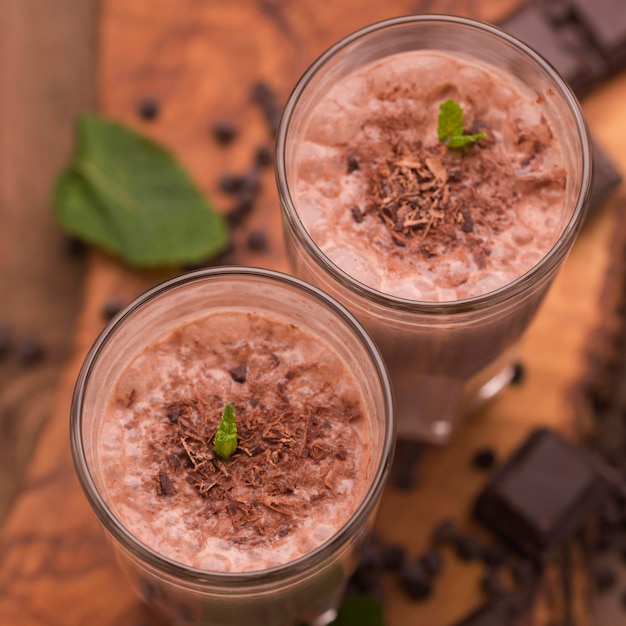 High angle of milkshake glasses with chocolate and mint