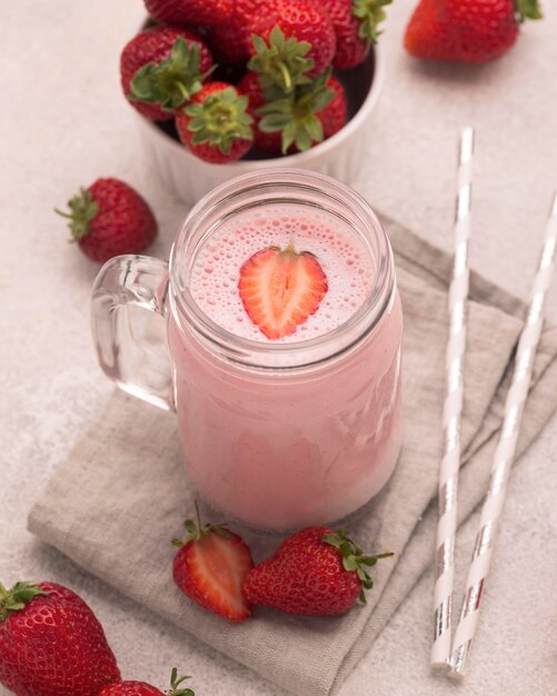 High angle of milkshake with straws and strawberries