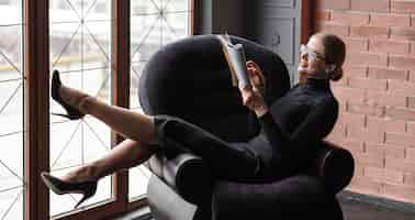 Free photo high angle modern woman reading magazine