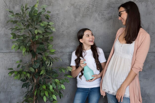 High angle mom and girl watering plant