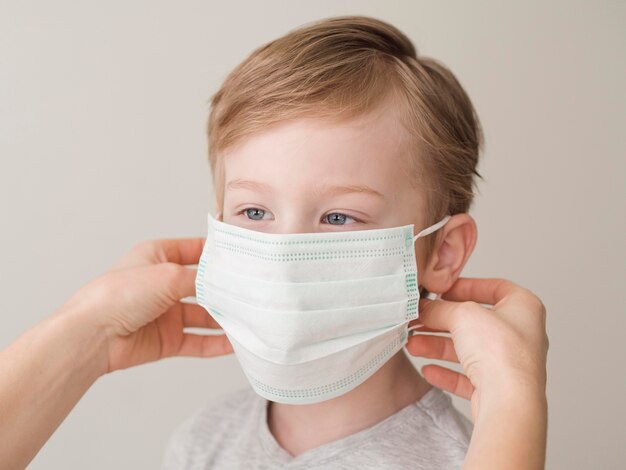 High angle mom putting on mask on boy