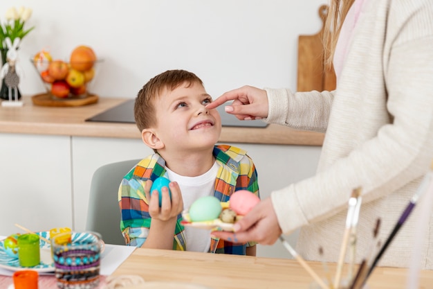 High angle mom with son making eggs for easter