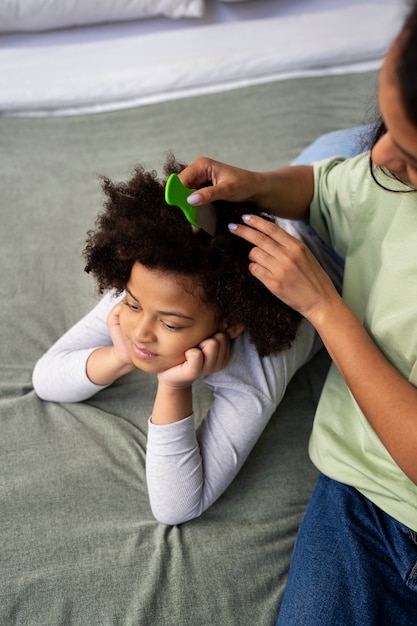 Madre dell'angolo alto che pettina i capelli della ragazza