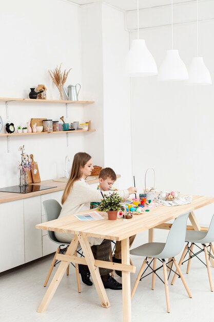 High angle mother and son at home painting eggs