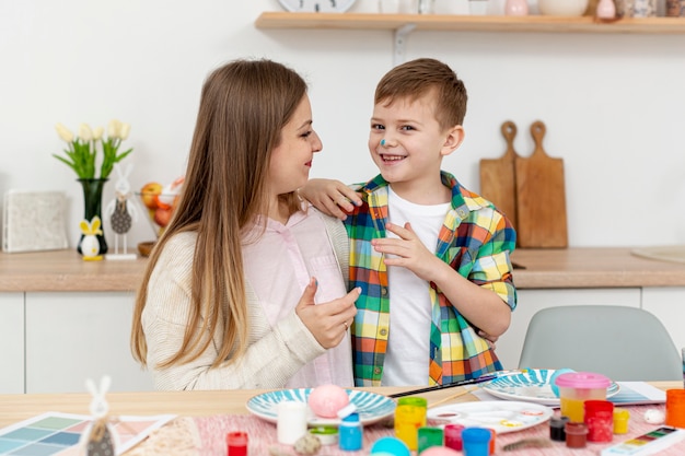 High angle mother and son painting eggs