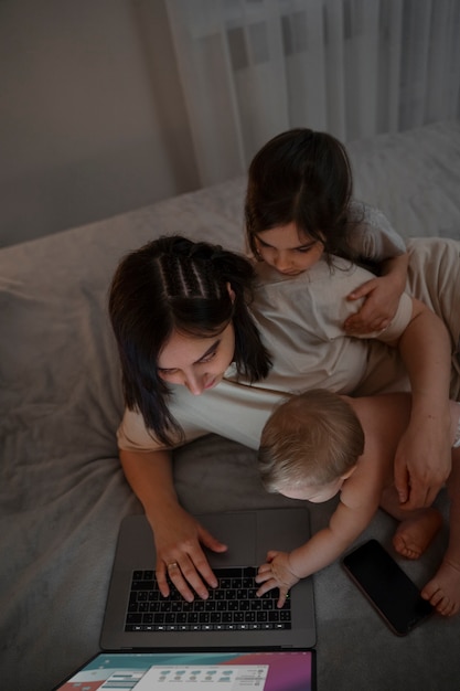 ラップトップと子供を持つ高角度の母