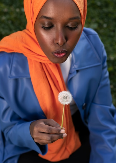 Foto gratuita donna musulmana dell'angolo alto che posa all'aperto