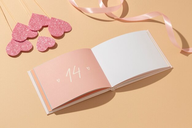 High angle of notebook with hearts and ribbon for valentines day