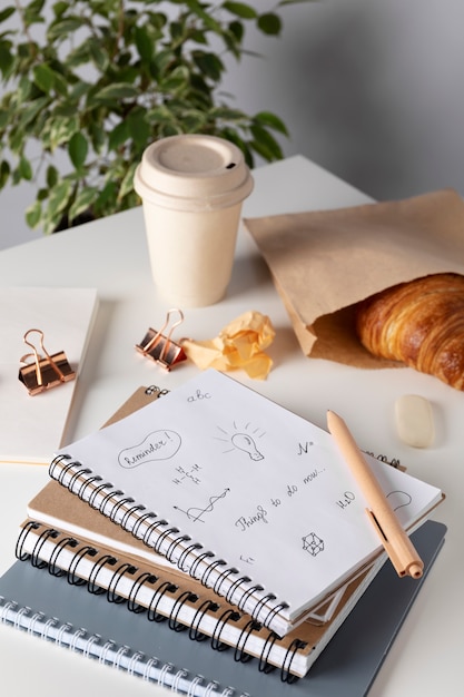 Free photo high angle notebooks and croissant