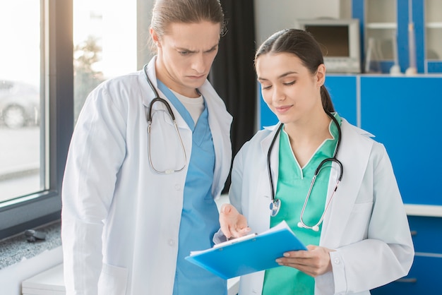 Free photo high angle nurses looking at clipboard