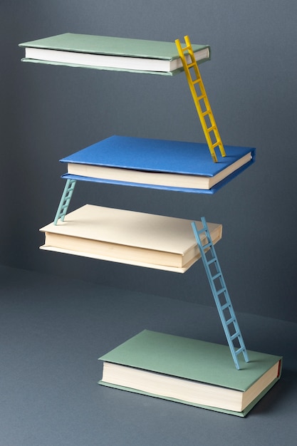 Бесплатное фото Высокий угол плавающих книг, соединенных лестницей в день обучения