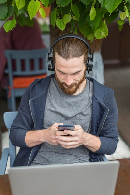Бесплатное фото Высокий угол человека на городской террасе с ноутбуком и смартфоном