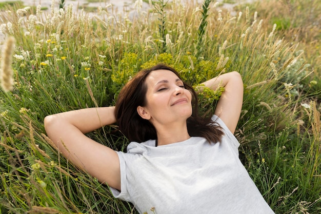 Бесплатное фото Высокий угол женщины расслабляющий на траве
