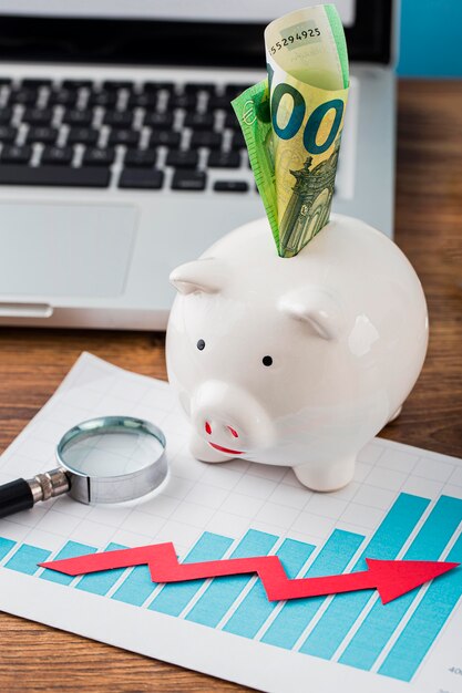 High angle of office items with piggy bank and growth chart