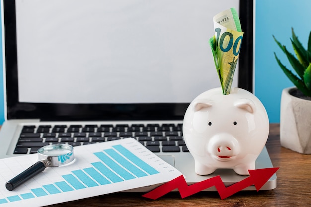 High angle of office items with piggy bank and laptop