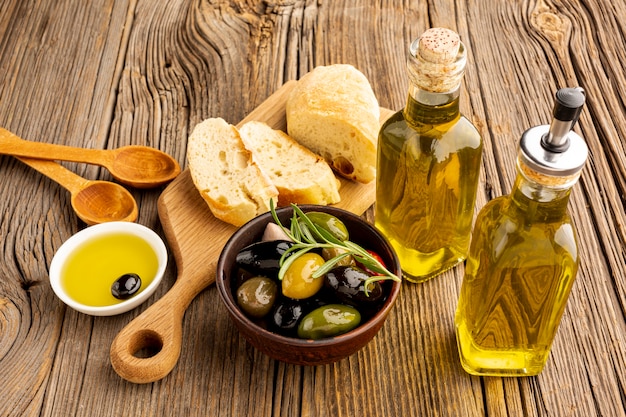 High angle olives mix bread and oil bottles