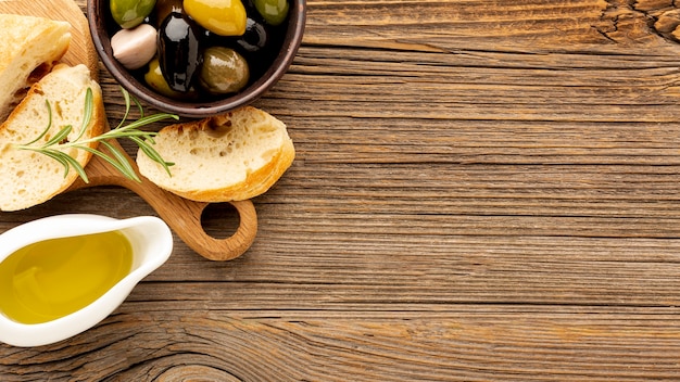 High angle olives mix bread and oil saucer with copy space