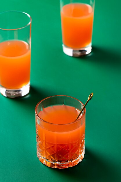 High angle orange drinks on green background