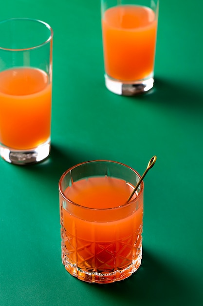 Высокий угол оранжевые напитки на зеленом фоне
