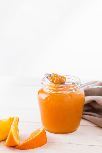 High angle of orange jam in transparent jar