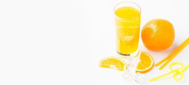 High angle of orange juice in glass with peel and copy space