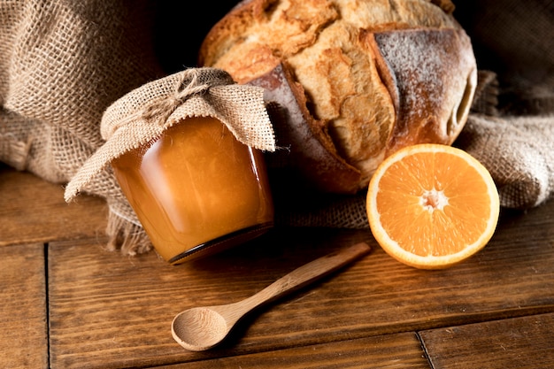 High angle of orange marmalade jar with bread