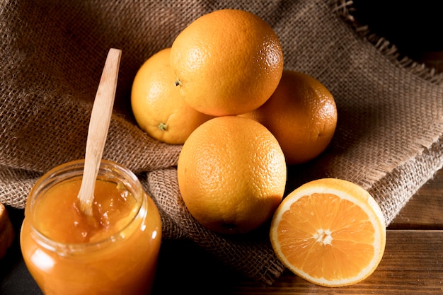 High angle of orange marmalade in jar with fruit