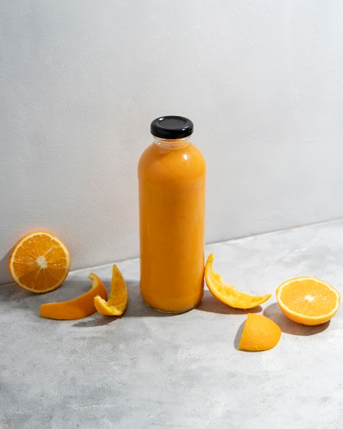 High angle oranges and juice bottle