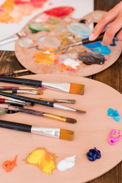 High angle of paint brushes with paint and palette