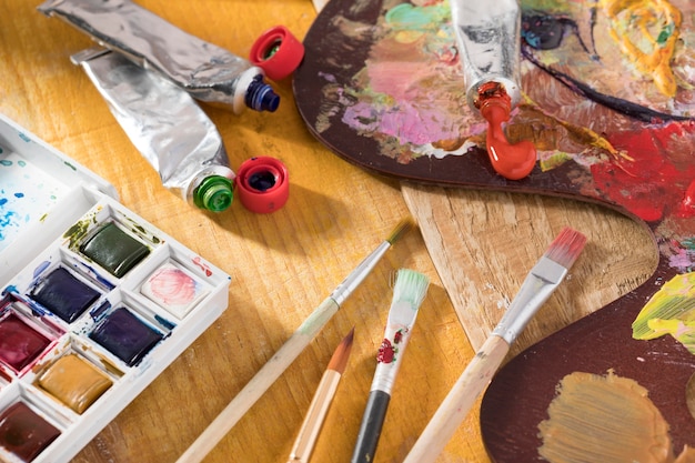 High angle of paint brushes with palette and paint