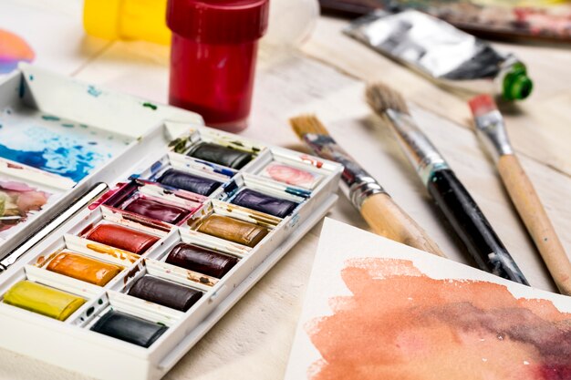 High angle of paint palette and brushes