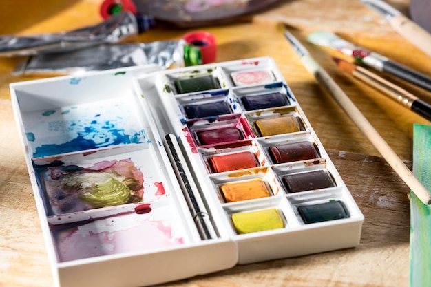 High angle of paint palette with brushes