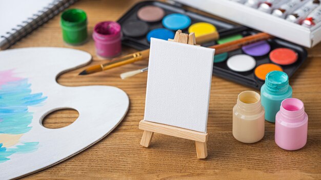 High angle of painting essentials with easel and palette