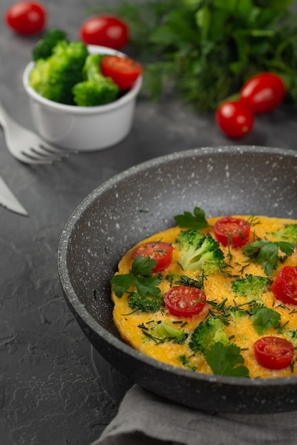 Foto gratuita alto angolo di padella con colazione frittata e pomodori