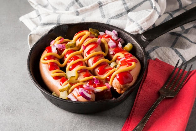 Foto gratuita padella ad alto angolo con salsicce e salse